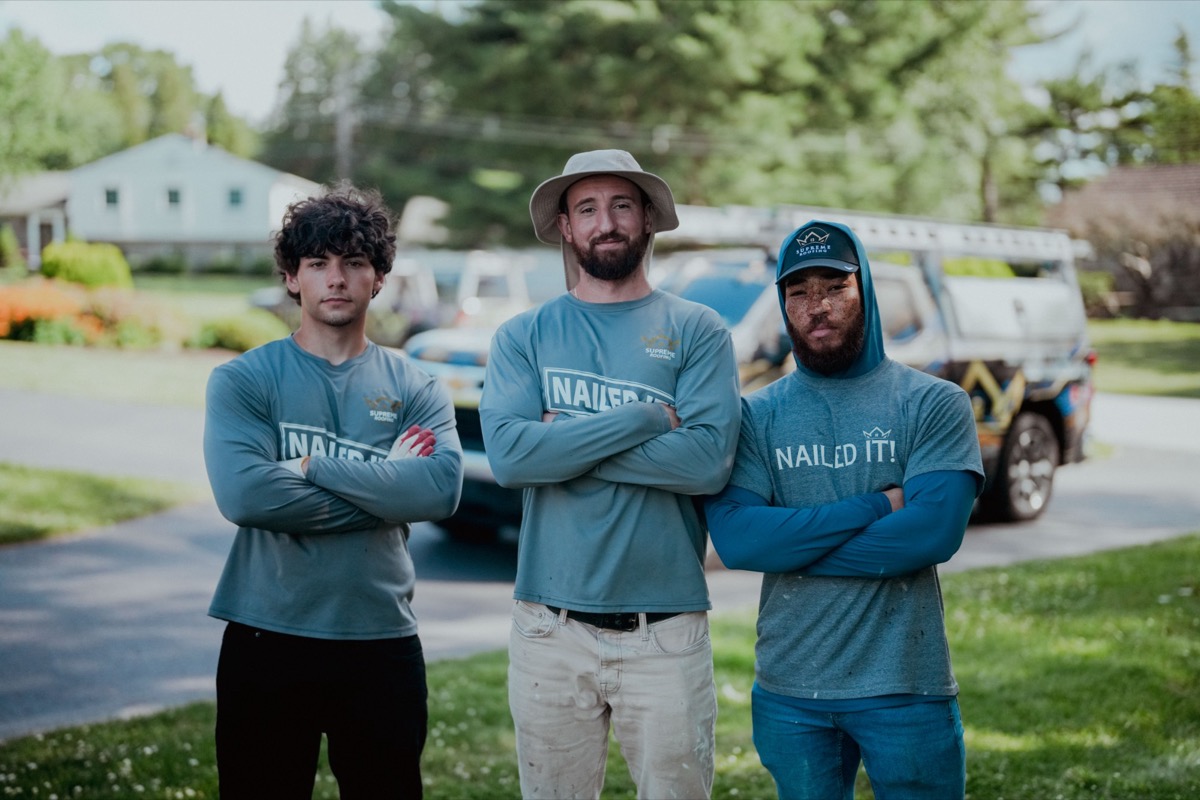 The Supreme Roofing crew standing in front of a completed roof replacement job